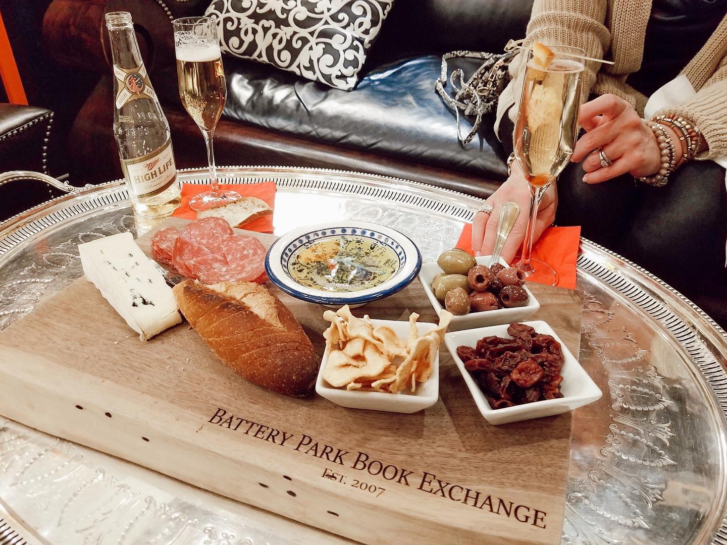 a hand grabbing lite bites and champagne