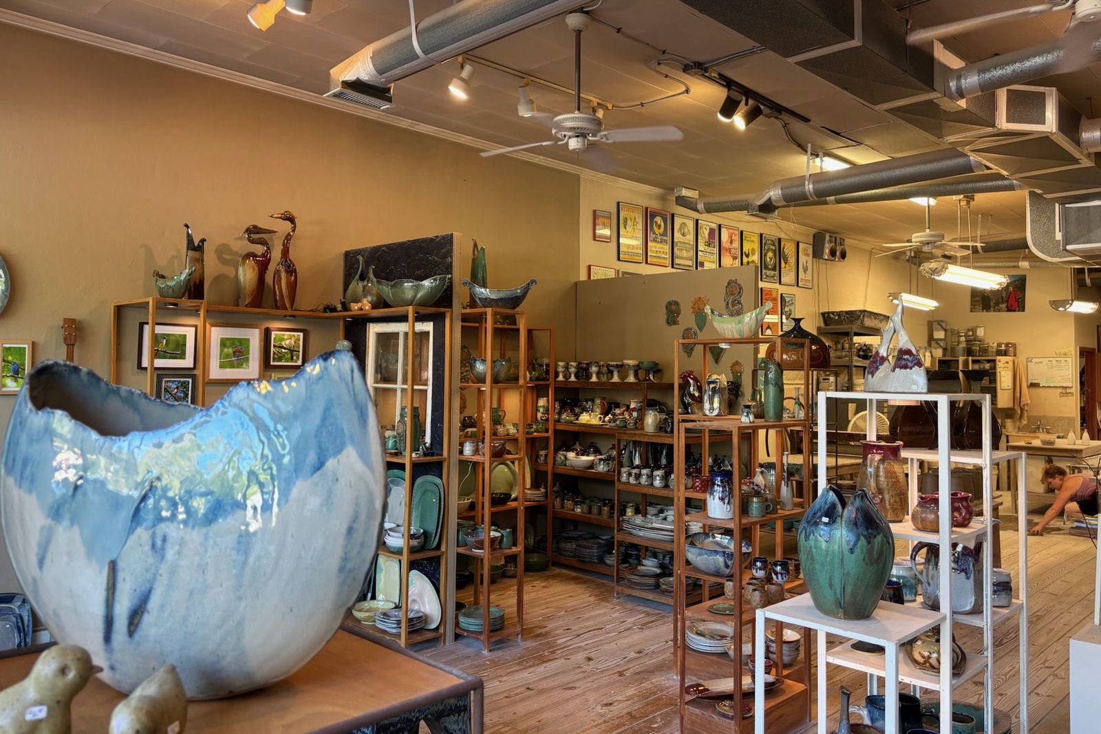weaverville-mangum-pottery-studio Handmade pottery on wood shelves with the working studio in back at Mangum Pottery in Weaverville